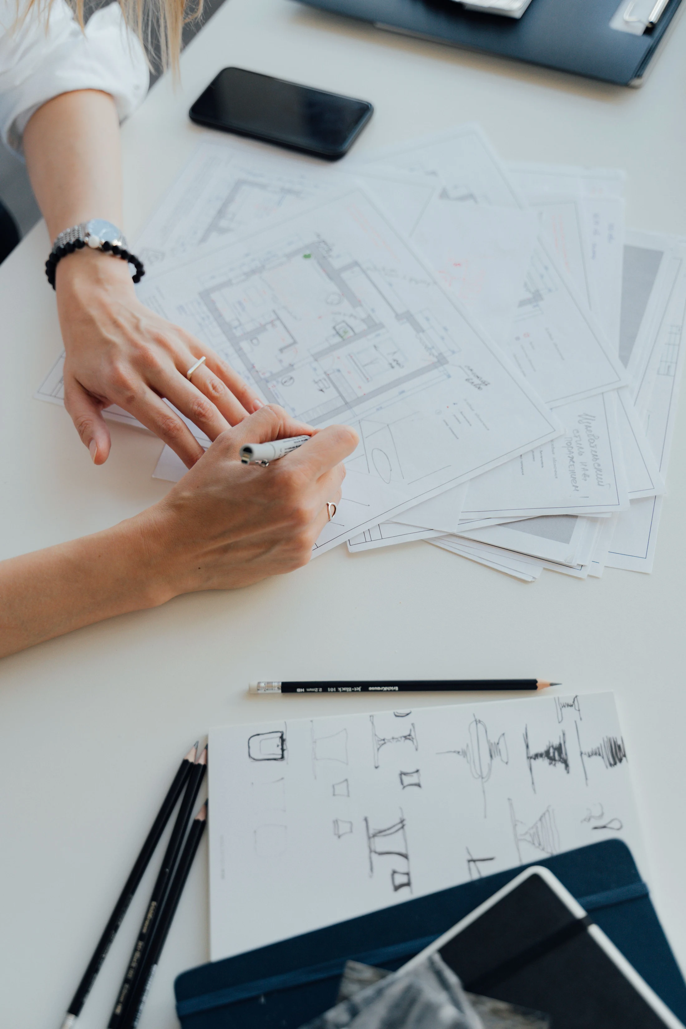 Hands working on architectural floor plans